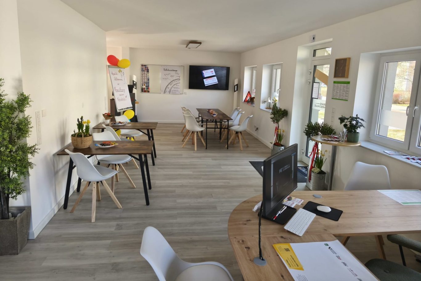 Raum mit Fernseher, Flipchart, einem Reifen und einem Warndreieck auf dem Boden.