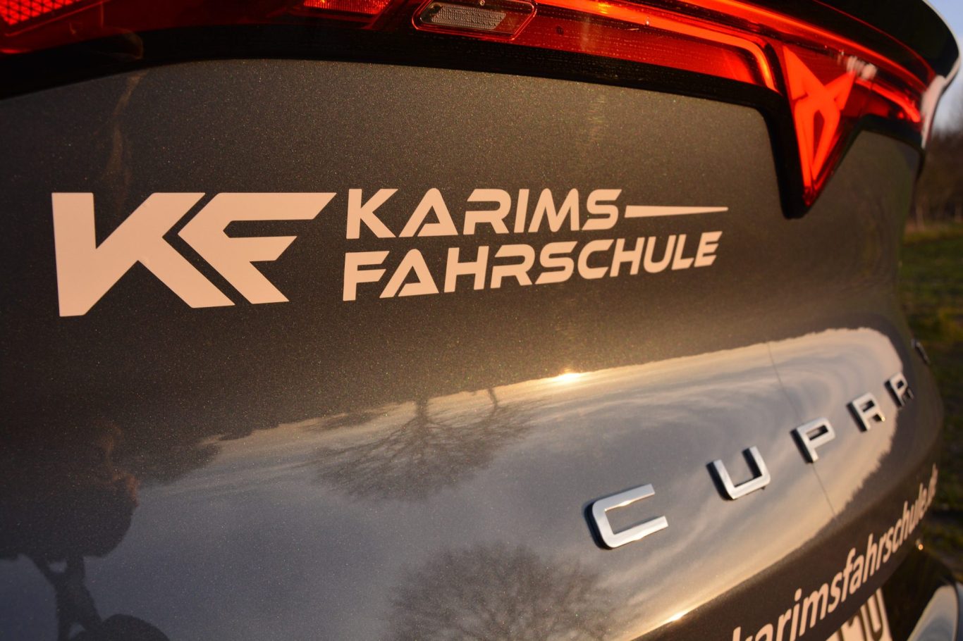 Logo von "Karims Fahrschule" auf der Heckklappe eines Fahrzeugs.
